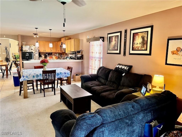 living room featuring arched walkways and light colored carpet