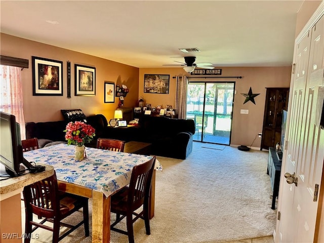 dining room with light carpet, ceiling fan, visible vents, and baseboards