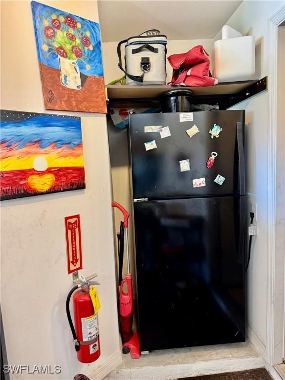 room details featuring freestanding refrigerator and a fire extinguisher