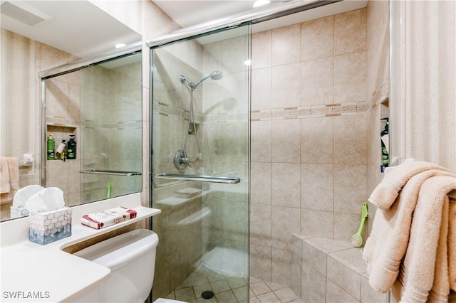 bathroom with toilet and an enclosed shower