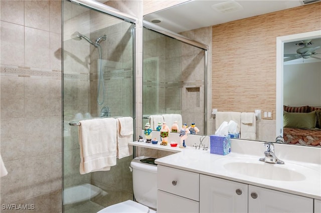 bathroom featuring vanity, toilet, and a shower with door