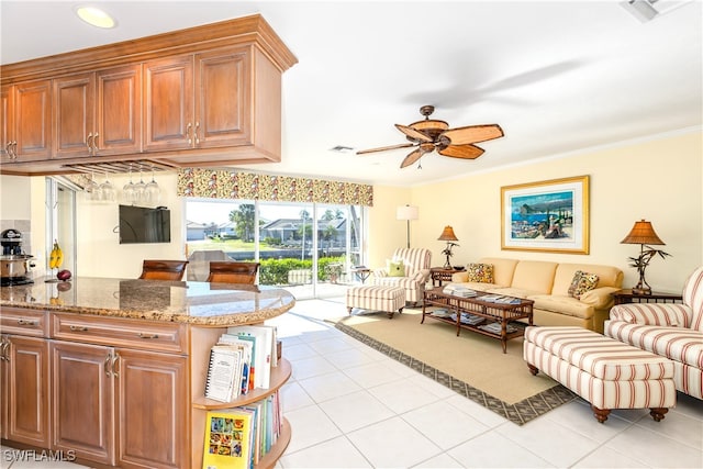 living room with light tile patterned floors, ceiling fan, and ornamental molding