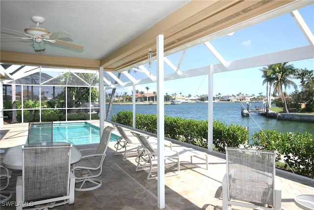 view of swimming pool with a lanai, a patio area, ceiling fan, and a water view