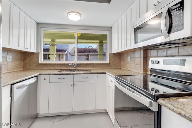 kitchen featuring stainless steel appliances, decorative backsplash, white cabinetry, and sink