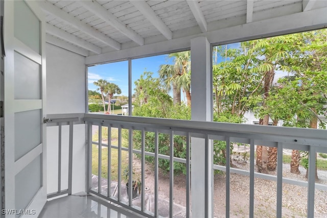 unfurnished sunroom with beamed ceiling