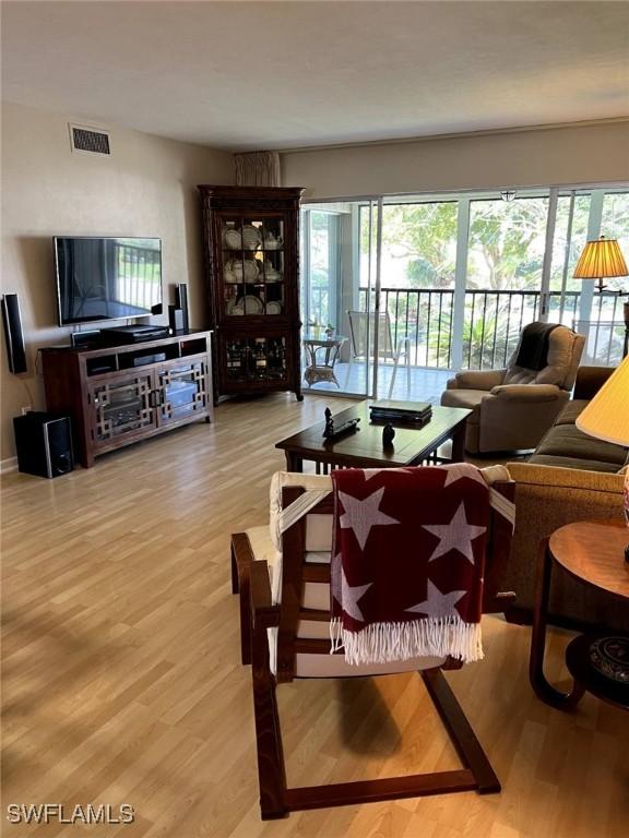 living room featuring visible vents and wood finished floors