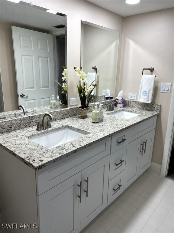 bathroom featuring double vanity, a sink, and tile patterned floors