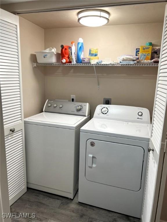 washroom with laundry area, washer and clothes dryer, and wood finished floors