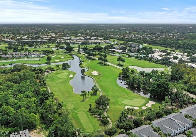 drone / aerial view with golf course view and a water view