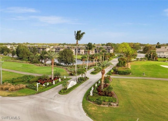 surrounding community with view of golf course, a yard, and driveway