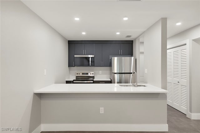 kitchen with visible vents, appliances with stainless steel finishes, dark cabinets, light countertops, and a sink