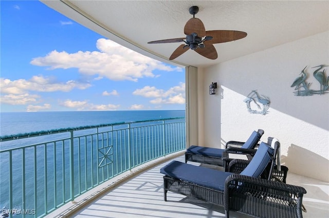 balcony featuring a ceiling fan and a water view