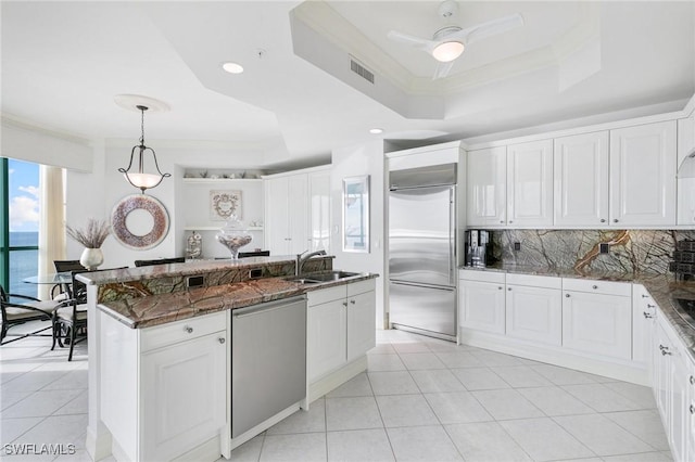 kitchen with visible vents, a tray ceiling, a sink, appliances with stainless steel finishes, and crown molding