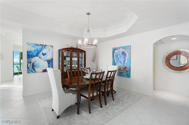 dining space with ornamental molding, a tray ceiling, light tile patterned floors, baseboards, and a chandelier