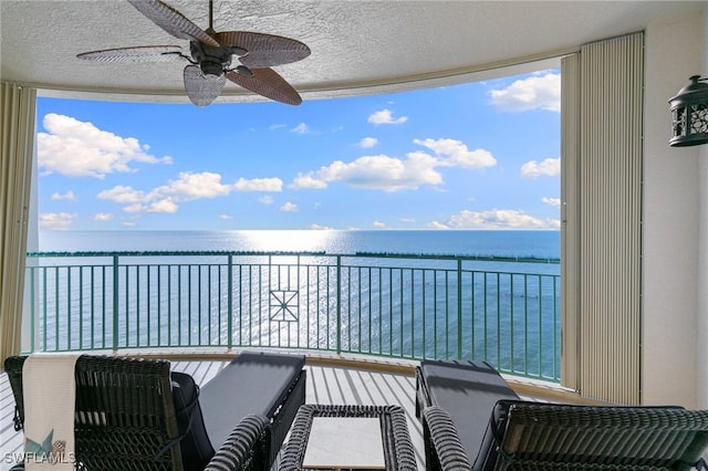 balcony featuring ceiling fan and a water view