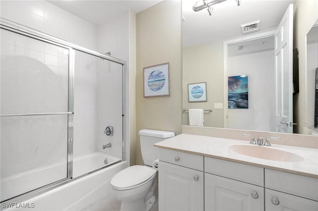 bathroom featuring visible vents, combined bath / shower with glass door, toilet, and vanity