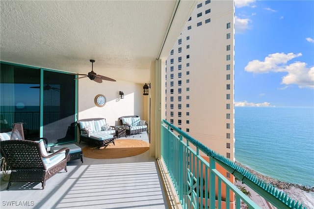 balcony featuring a ceiling fan and a water view