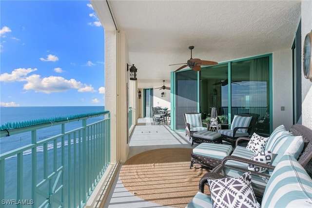 balcony with a water view and a ceiling fan