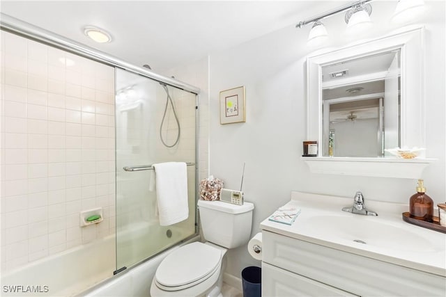 full bathroom featuring vanity, combined bath / shower with glass door, and toilet