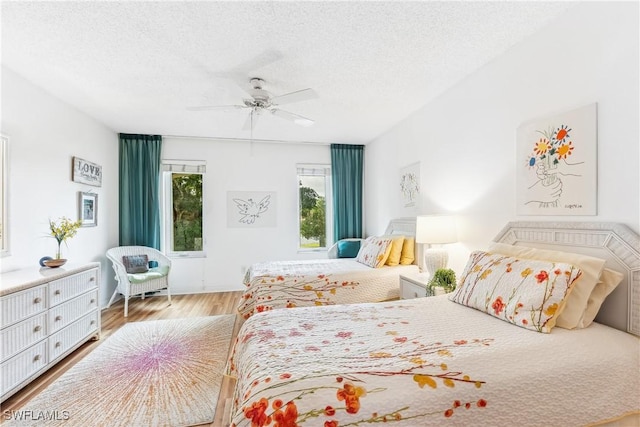 bedroom featuring ceiling fan, a textured ceiling, and light wood-type flooring