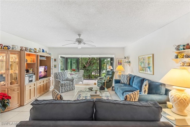 living room featuring ceiling fan, a textured ceiling, and light tile patterned floors