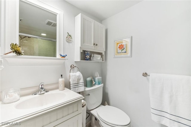 bathroom with walk in shower, vanity, and toilet