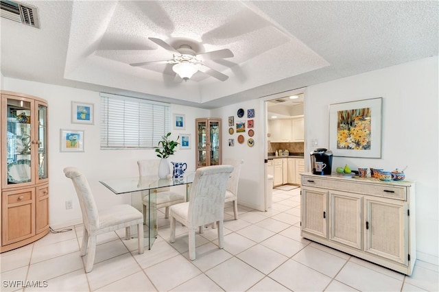 1760 Bald Eagle Dr Unit 506B, Naples, FL 34105 - dining space featuring a tray ceiling, ceiling fan, light tile patterned floors, a textured ceiling, and baseboards