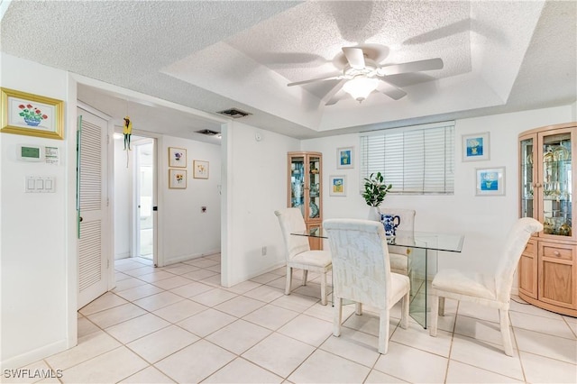 1760 Bald Eagle Dr Unit 506B, Naples, FL 34105 - dining area with a tray ceiling, ceiling fan, a textured ceiling, light tile patterned floors, and baseboards