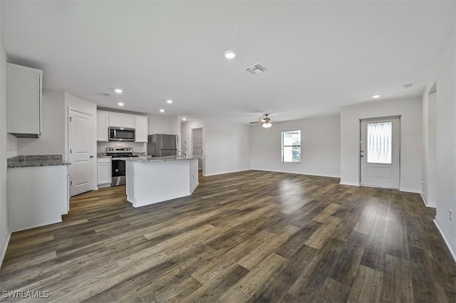 kitchen with appliances with stainless steel finishes, ceiling fan, white cabinets, a center island, and dark hardwood / wood-style floors