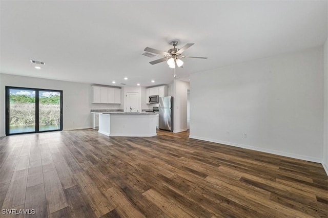 unfurnished living room with dark hardwood / wood-style floors and ceiling fan