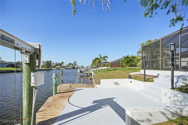 dock area with a water view, boat lift, a lanai, and a yard