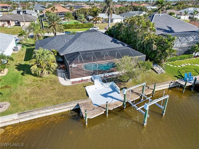 dock area featuring a lanai, a yard, and a water view