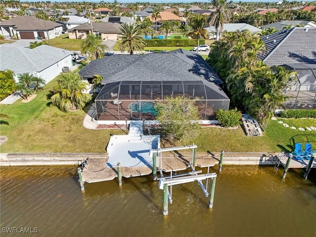 view of dock featuring a lawn, glass enclosure, and a water view