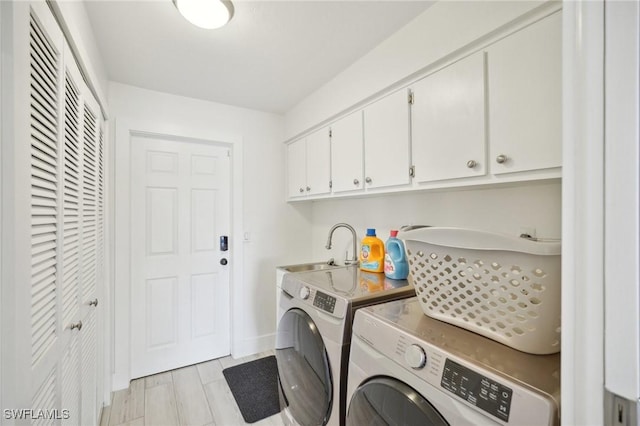 laundry area with independent washer and dryer, cabinets, and sink