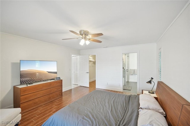 bedroom featuring ornamental molding, connected bathroom, ceiling fan, wood finished floors, and baseboards