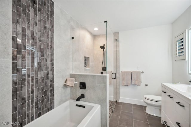 bathroom featuring toilet, tile patterned floors, a bathtub, a tile shower, and vanity