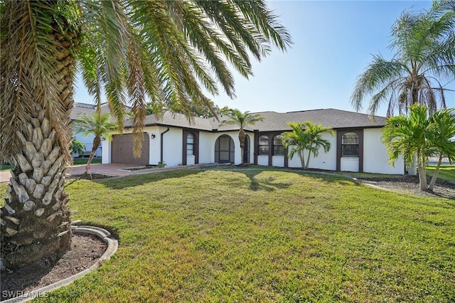 view of front facade featuring a garage, a front lawn, and stucco siding