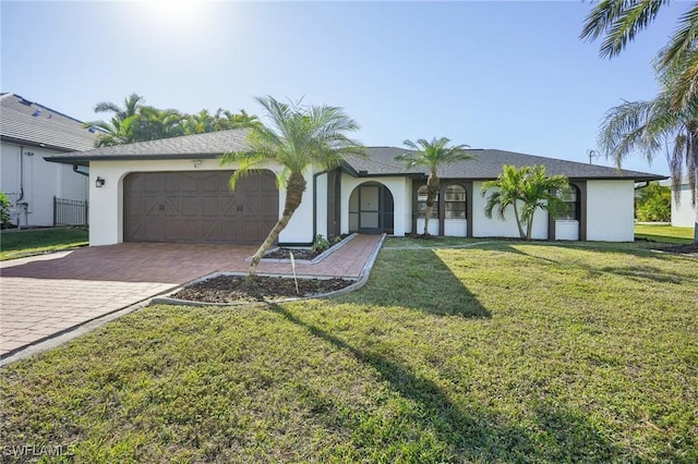 view of front of property featuring decorative driveway, an attached garage, a front yard, and stucco siding