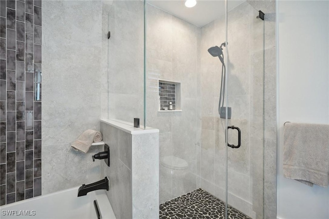 bathroom with a washtub and tiled shower