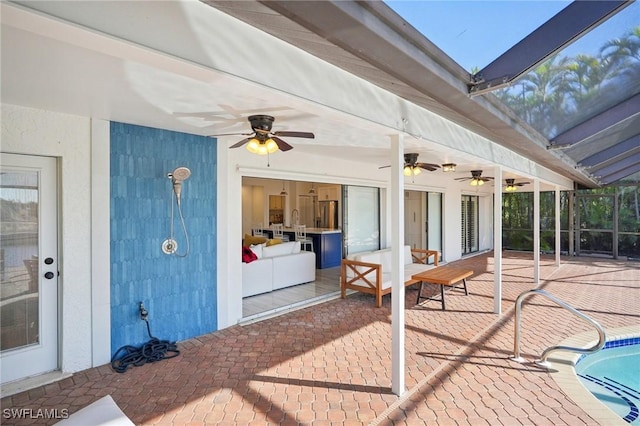 view of patio featuring a ceiling fan, glass enclosure, and an outdoor pool