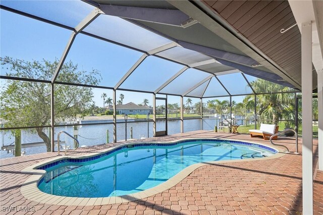 view of pool featuring a patio, a water view, and glass enclosure