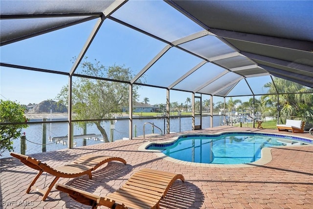 view of pool featuring a patio area, glass enclosure, and a water view