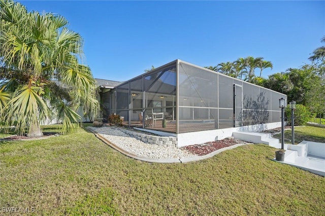 back of property with a patio area, glass enclosure, and a lawn