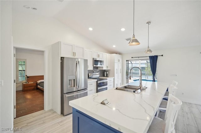 kitchen featuring sink, a center island with sink, appliances with stainless steel finishes, and white cabinetry