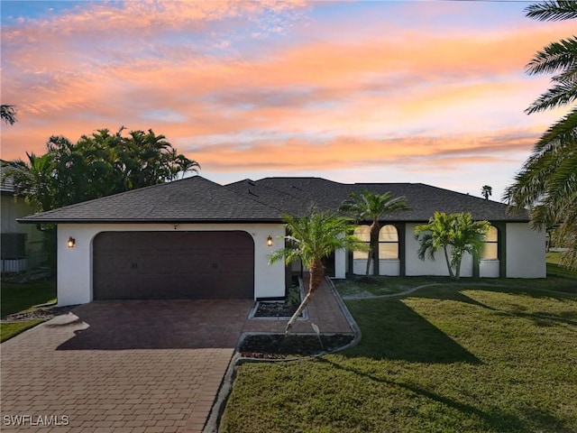 view of front of property with a yard and a garage