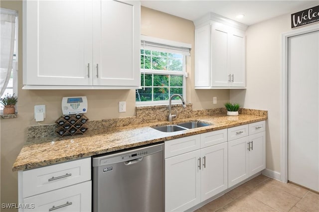 kitchen with white cabinetry, dishwasher, light stone countertops, sink, and light tile patterned floors