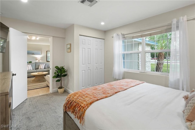 bedroom featuring light carpet and a closet