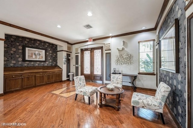 sitting room featuring ornamental molding, light hardwood / wood-style flooring, a wealth of natural light, and french doors