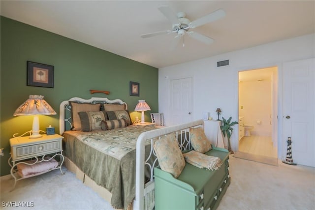 carpeted bedroom with ceiling fan and ensuite bath