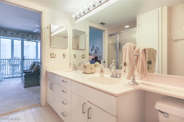 bathroom with ceiling fan, a shower with door, and vanity